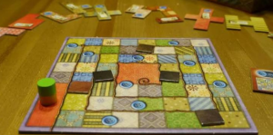 Patchwork board game showing two quilt boards filled with colorful fabric tile pieces
