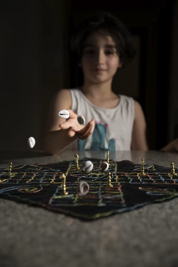 A girl tossing cowrie shells while playing Chaupar, one of India's oldest traditional board games.