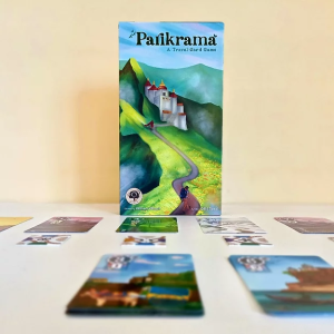 The box for Parikrama, Zenwood Games' travel-themed card game, displayed with playing cards on a table.